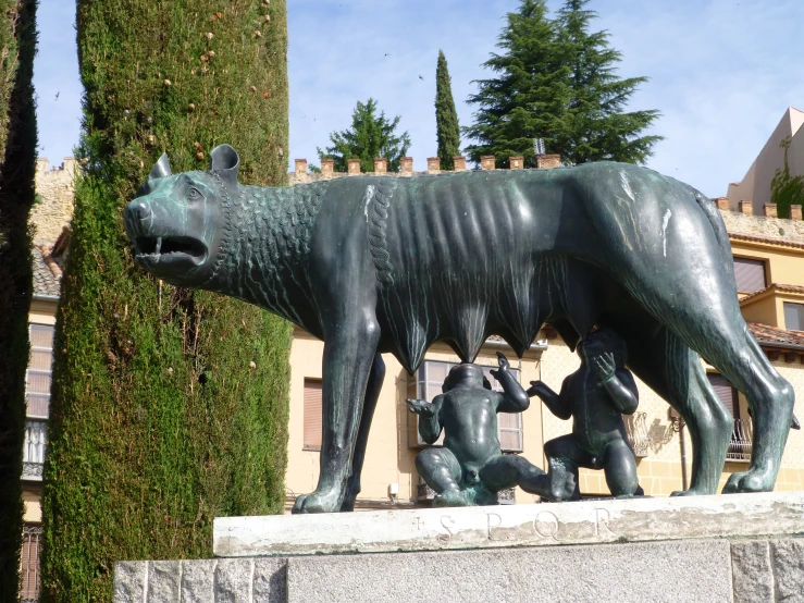 a statue of a bull and two children standing in front of a building