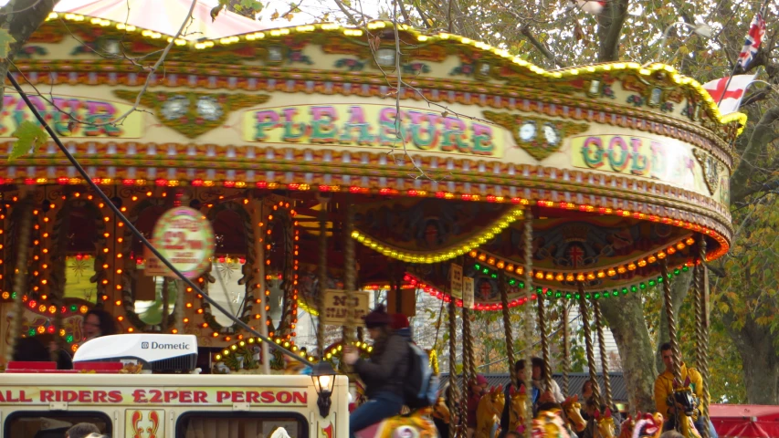 people ride on the carousel in the park