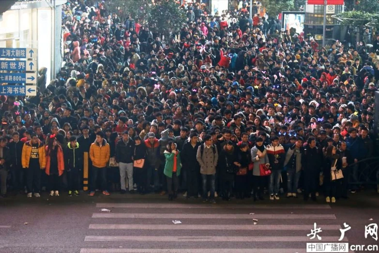 people standing in the middle of the road waiting for the red light