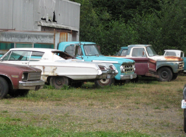 old cars sitting outside in a row in front of a building