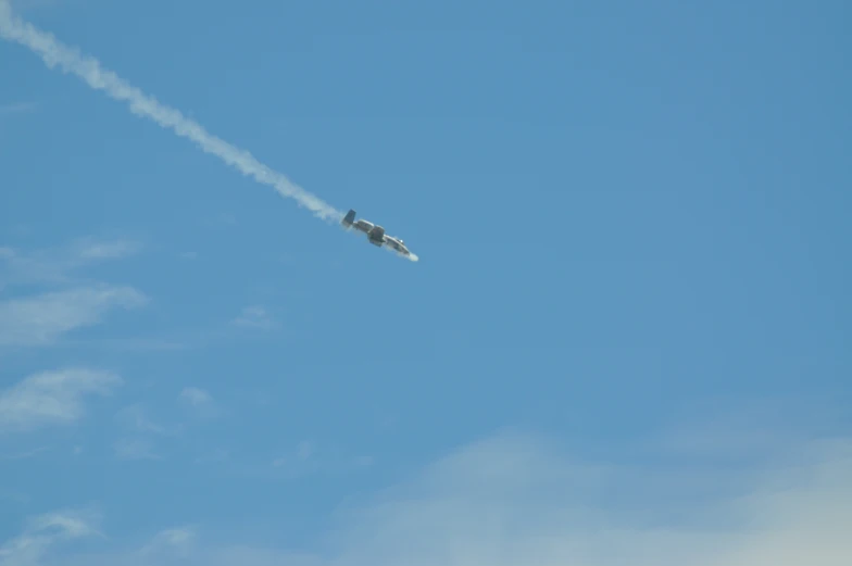 an airplane flying upside down and trailing smoke