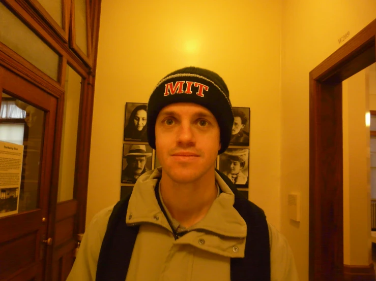 a young man wearing a hat in a hallway