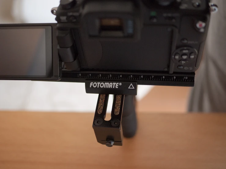 a camera being attached to a tripod on a wooden table