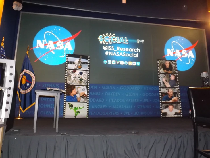 stage with nasa images on the screen and signs