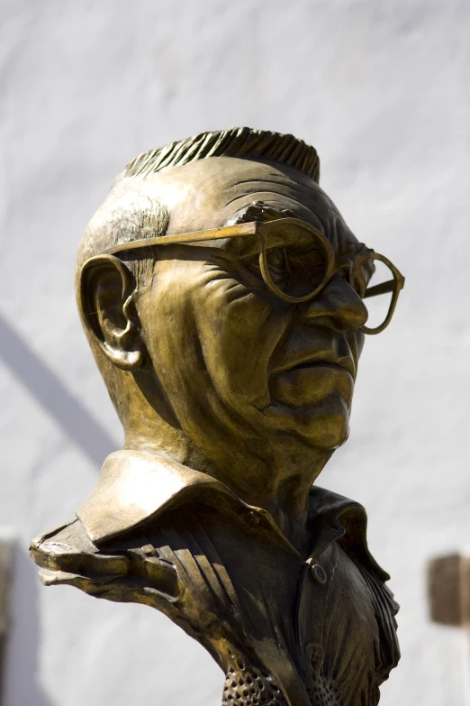 a bronze statue of a person with glasses and a jacket