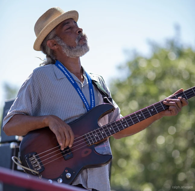 a man with a white beard and beard plays a guitar