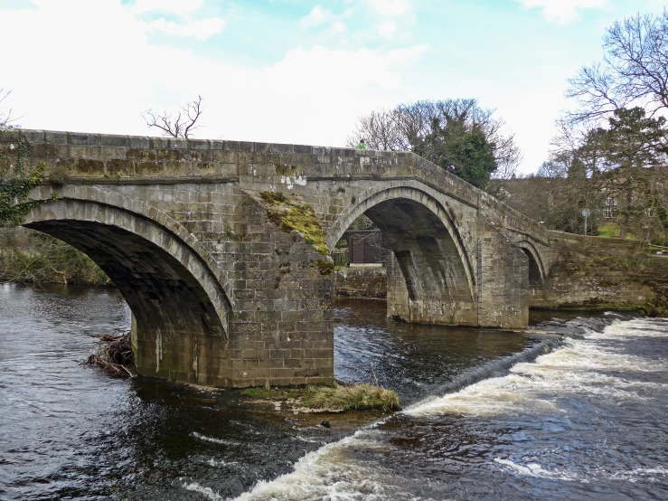 an old stone bridge over the water