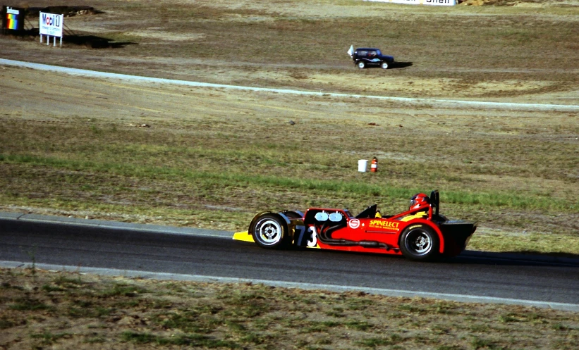 a man riding a race car down the middle of a track