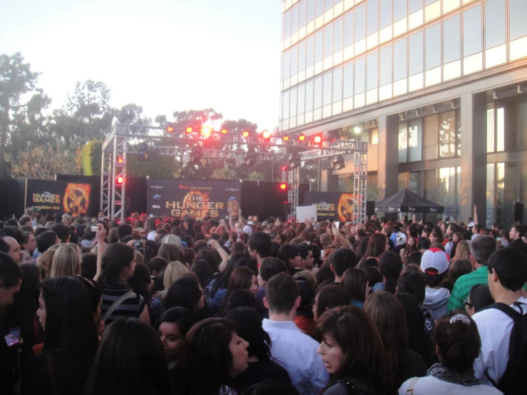 a crowd of people are gathered together in front of a stage