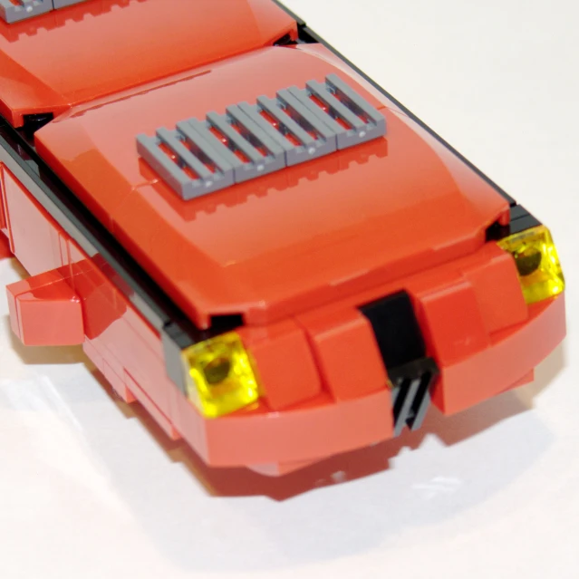a lego bus on a white surface with yellow light
