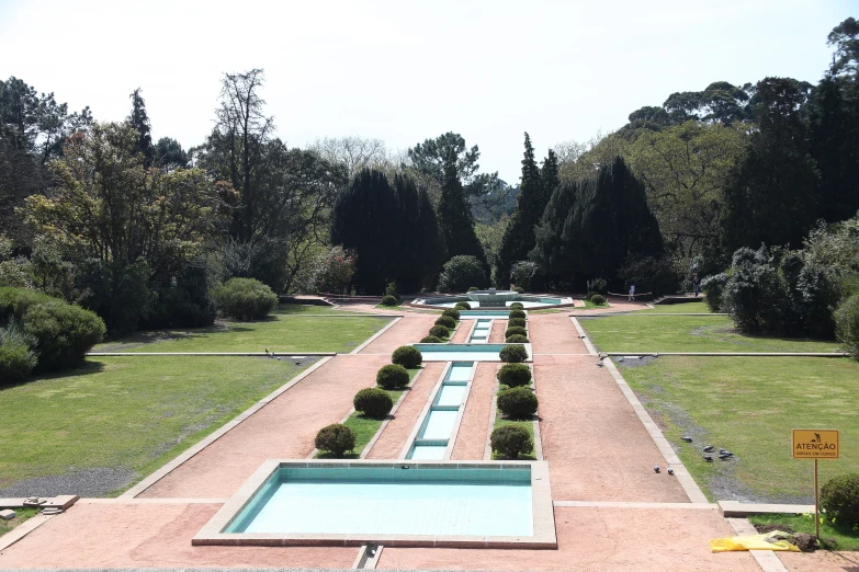 a very long row of benches at the end of a garden