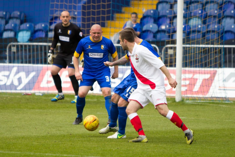 two men playing soccer in a stadium next to a goal