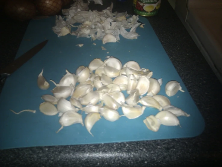 there are many peeled garlic on the  board