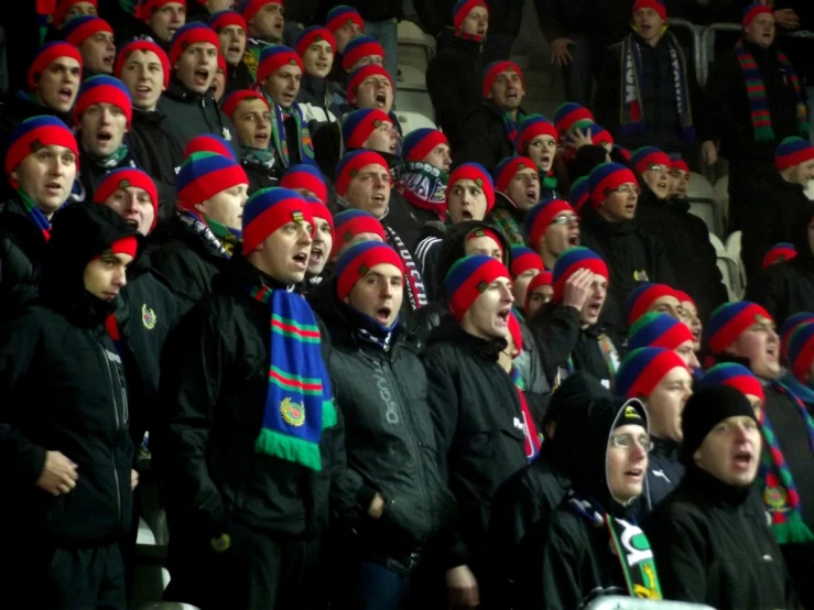 the crowd is wearing brightly colored hats and scarves