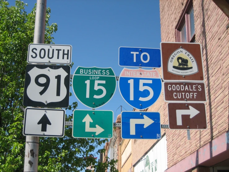 the road signs are posted near a brick building