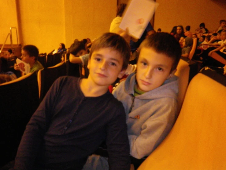 two boys in chairs at a movie theatre