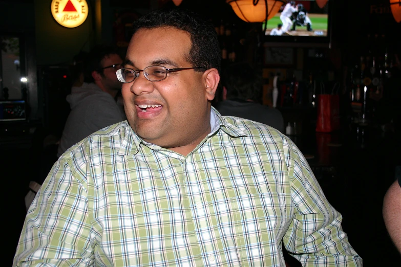 a man sitting in front of a bottle filled wine