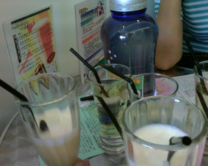 a person holds a pair of drinks near the glasses