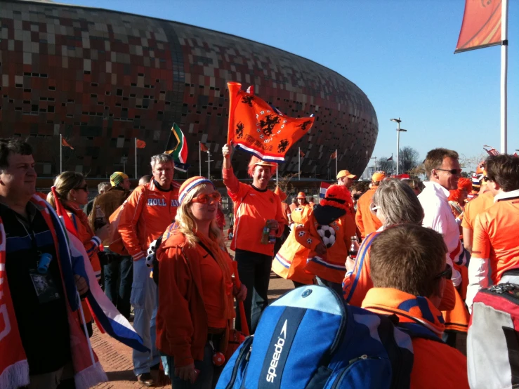 a bunch of people in orange jackets standing near each other