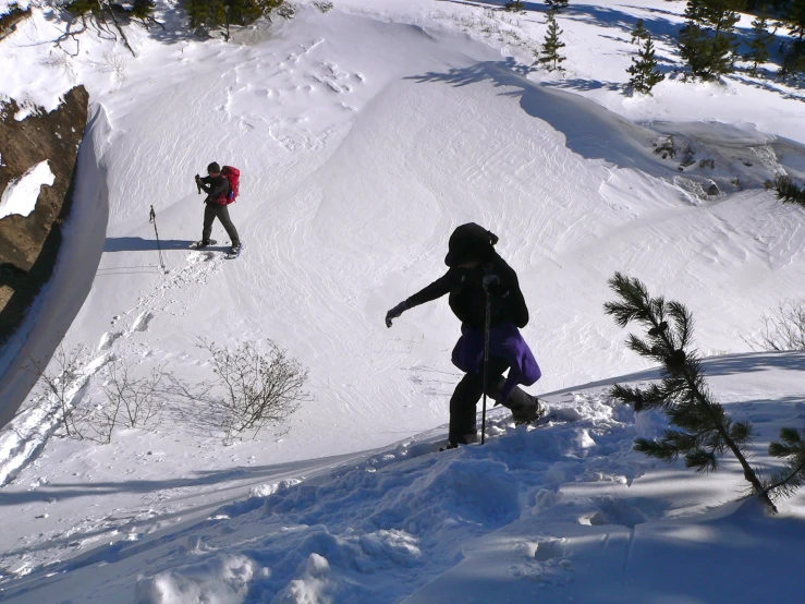 two people who are skiing down a snowy hill