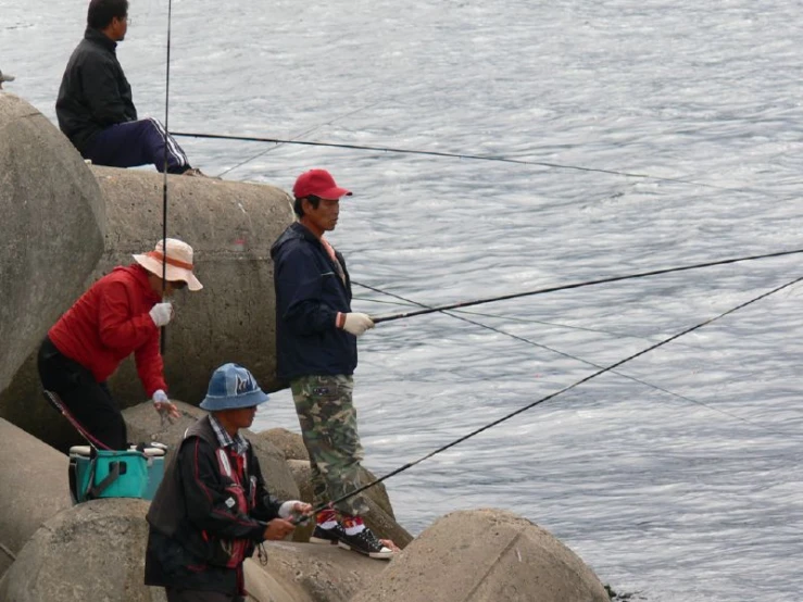 a group of people on a rocky shore fishing