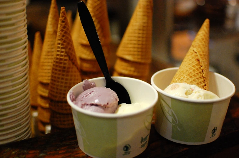 ice cream in cups sitting on top of a wooden table