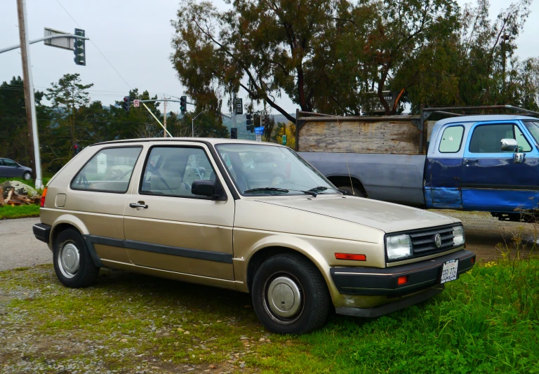 an old car is parked on the grass in front of two older cars