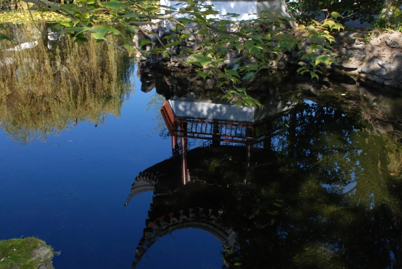 the reflection of a chair in a pond