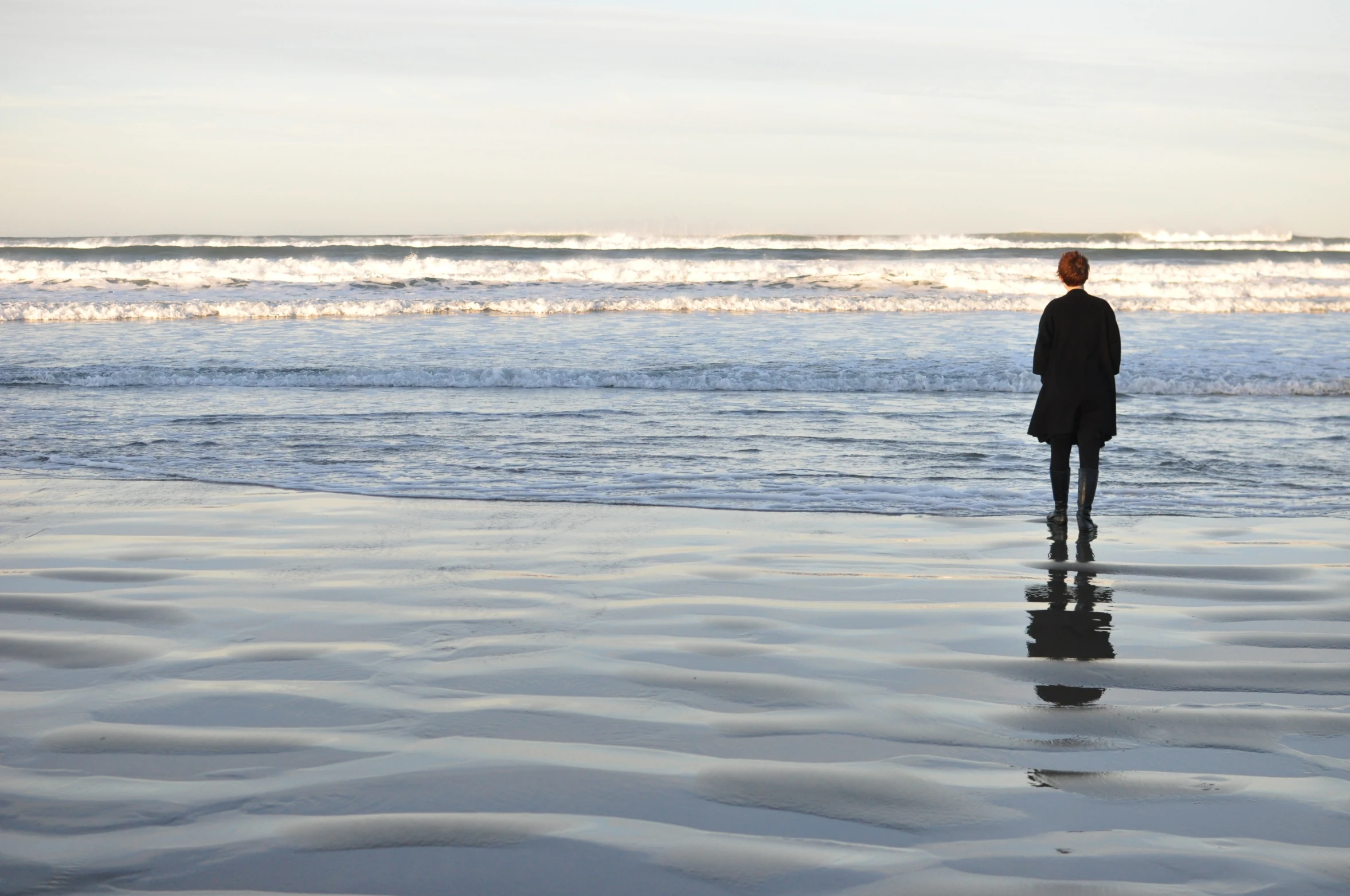 a person stands on the edge of a beach