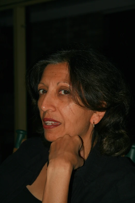 a woman in black shirt with hand on wrist