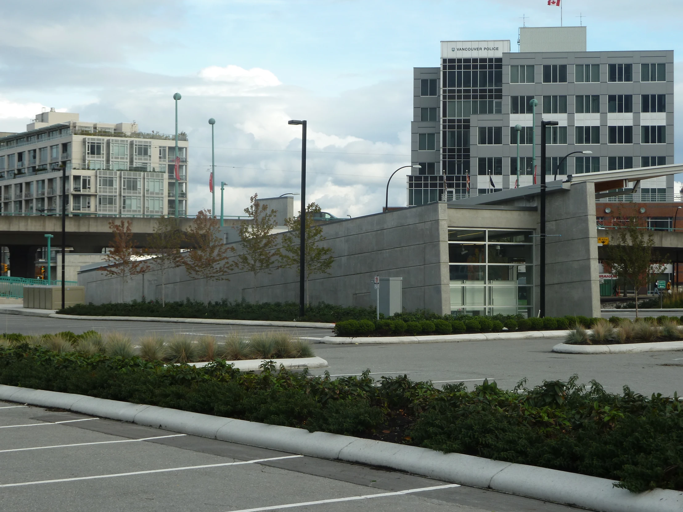 an empty parking lot in front of buildings with large windows