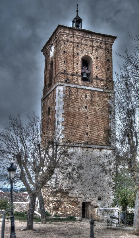 an old brick clock tower under a cloudy sky