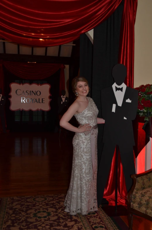 woman dressed in elegant gats and gown posing with costume