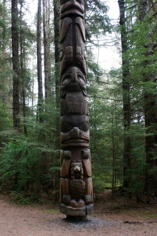 a carved totema standing in the middle of a forest