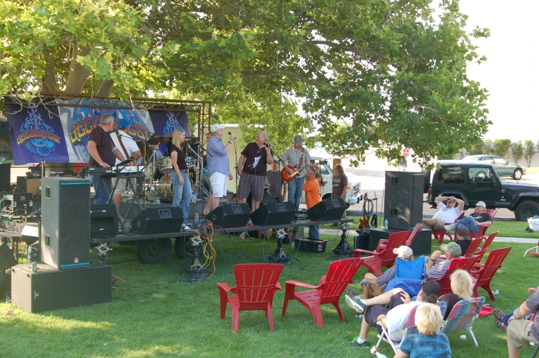 people watching a music show from chairs in the grass