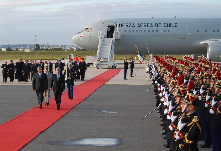 the president walks with his military men down the runway