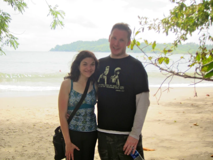 a man and a woman standing on top of a beach