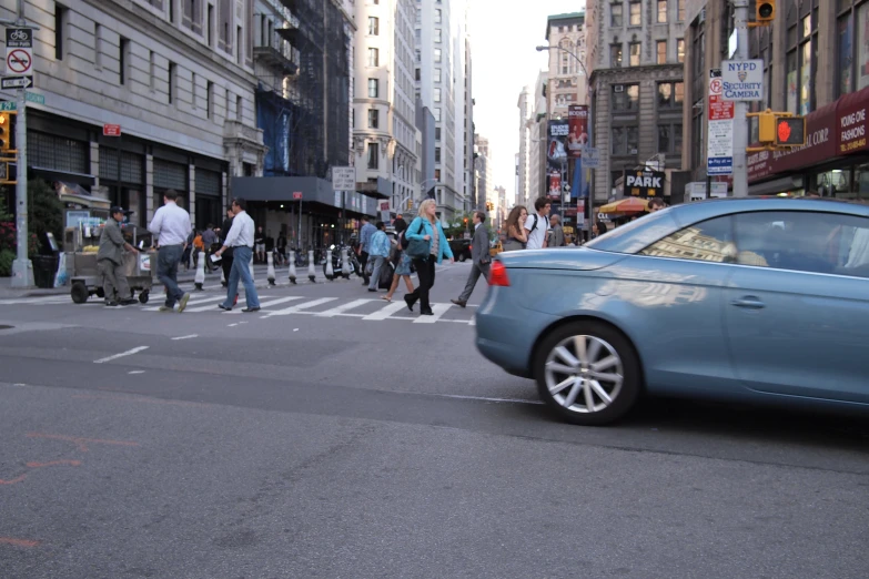 a couple of people crossing the street while hing a stroller