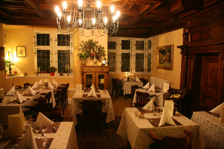 a restaurant with wooden ceilings and chandelier in the middle