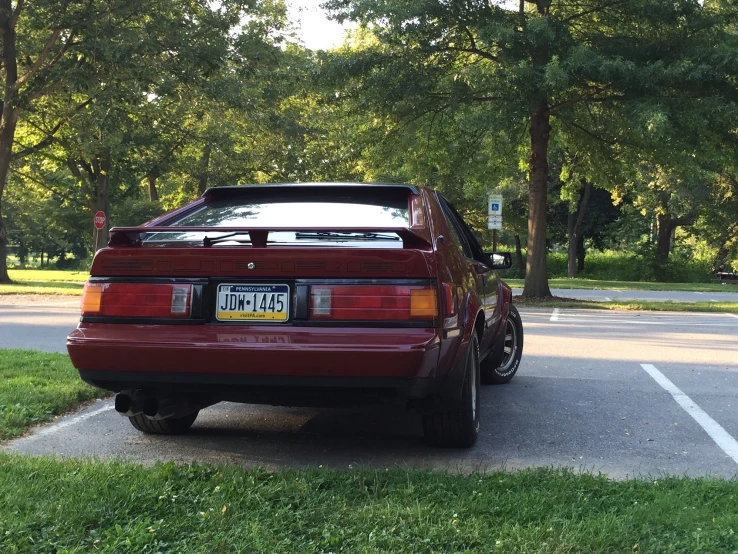 a car parked in a parking space next to a grass covered field