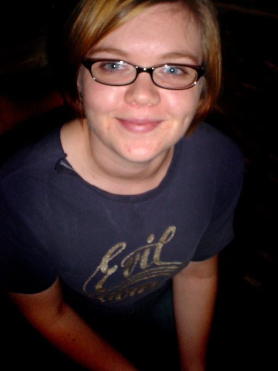 a girl wearing glasses smiling at the camera