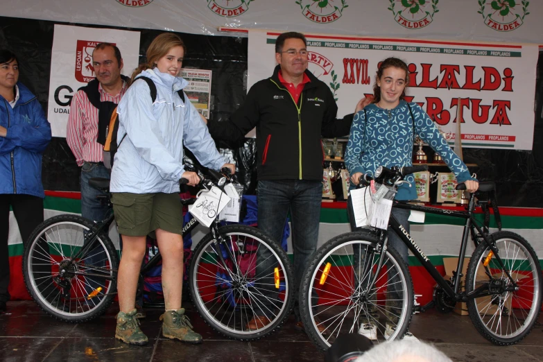 a group of men and women standing next to some bikes