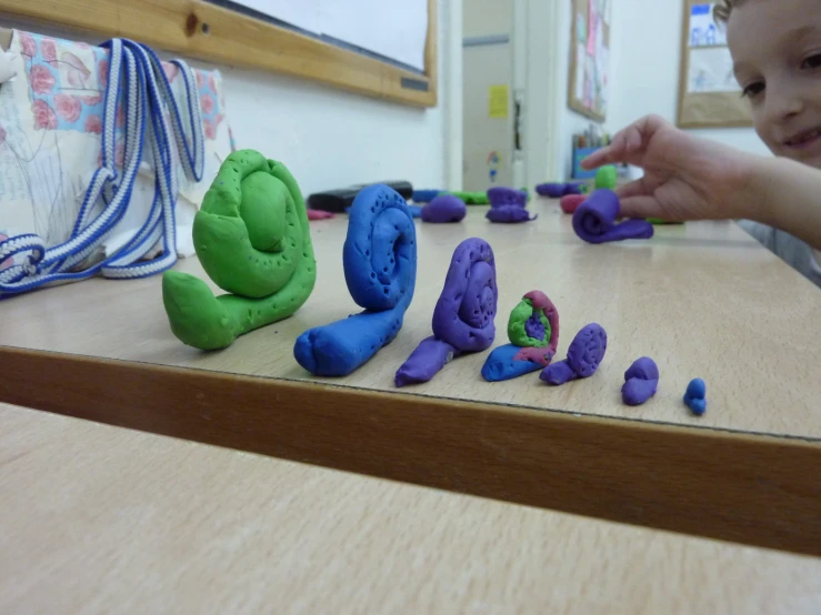 a child is making dough with colorful play doughs