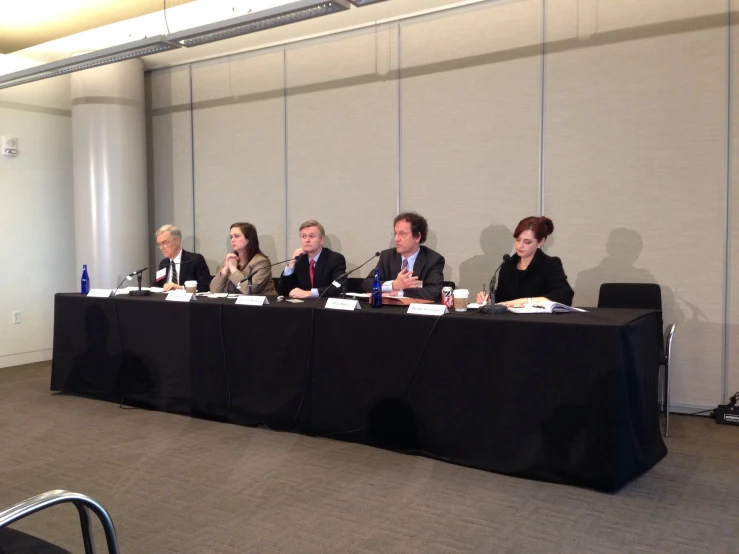 a table with four people at it and a few microphones