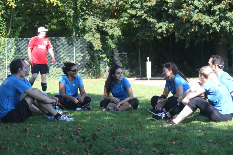 young people on sports teams, sitting down in the grass