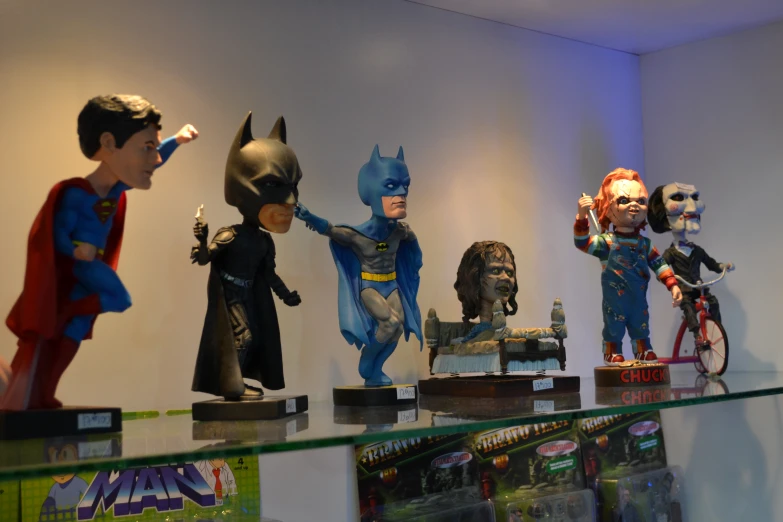 statues of superheros and villaines on a glass case