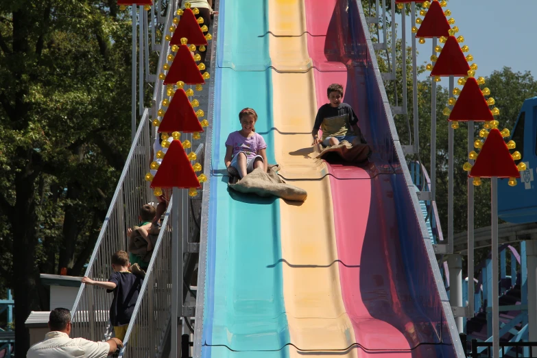 children play on a giant slide in a carnival park