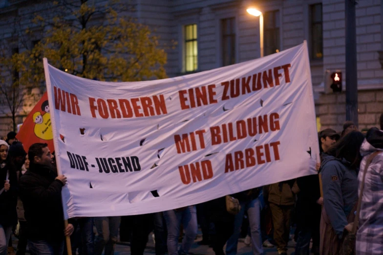 a crowd of people holding signs and holding a banner