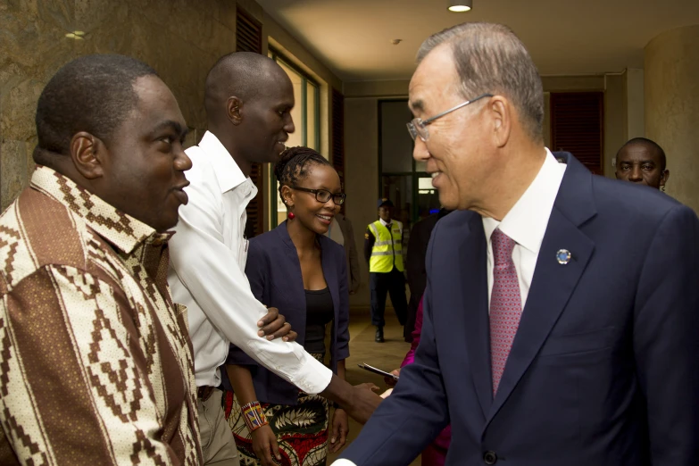 a man with glasses shaking hands with people