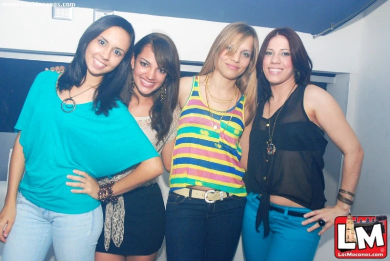 four women are standing together in front of a mirror